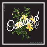Close up of t-shirt graphic of yellow sticky monkey flowers overlaid with cursive Oakland wordmark in a white square.