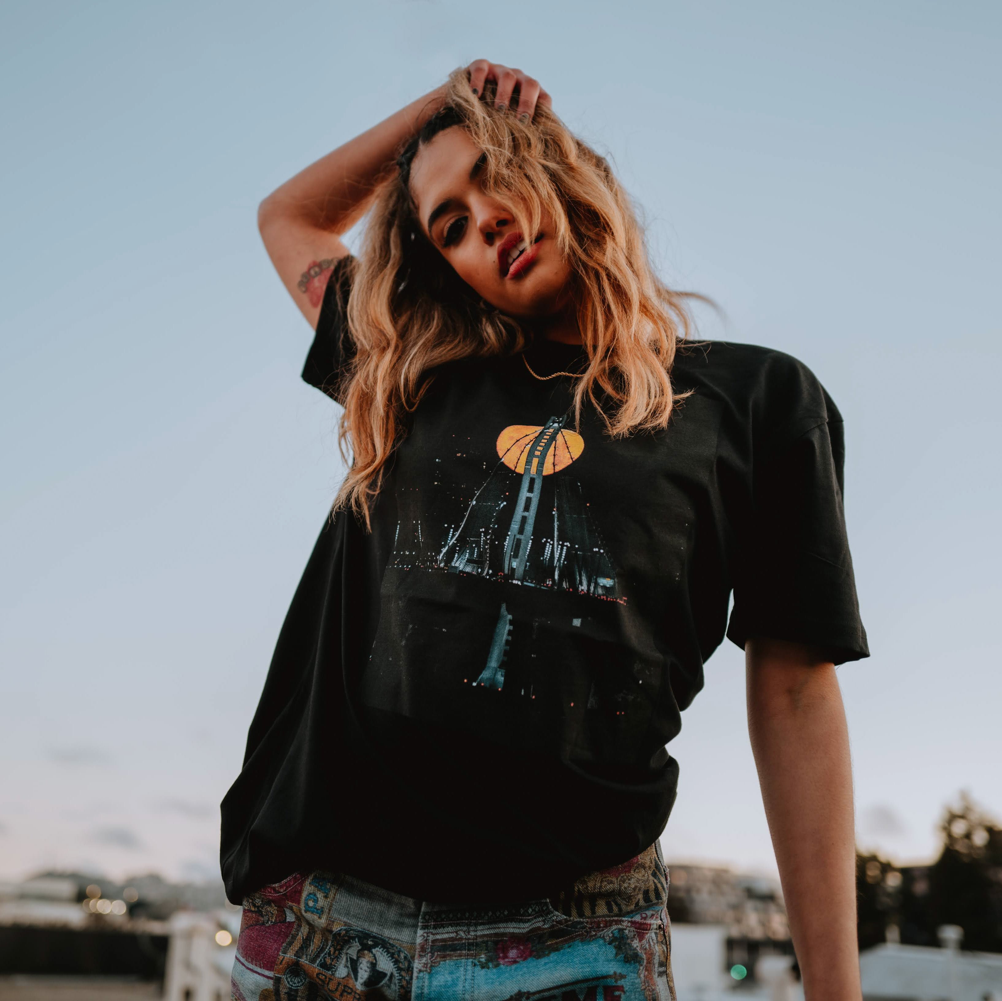 Female model wearing black t-shirt with Voncent James' Strawberry Moon image.