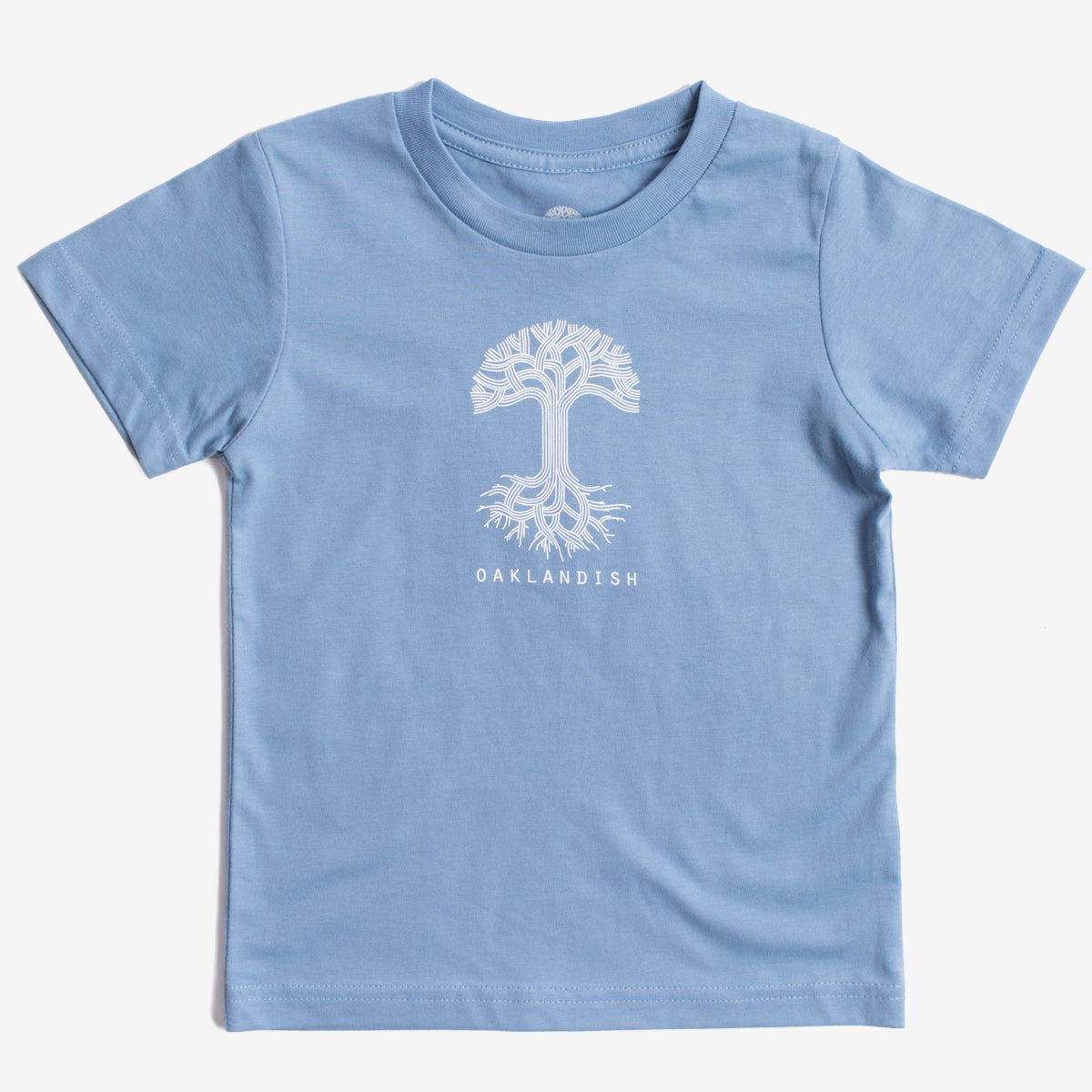 Introducing the Toddler Oaklandish Classic Logo Tee by Oaklandish: a Carolina blue short-sleeve t-shirt showcasing a white graphic of a tree with its roots, symbolizing the tree of life. The word "OAKLANDISH" is printed in white uppercase letters below the tree. Crafted from 100% cotton, this shirt is displayed flat against a plain white background.