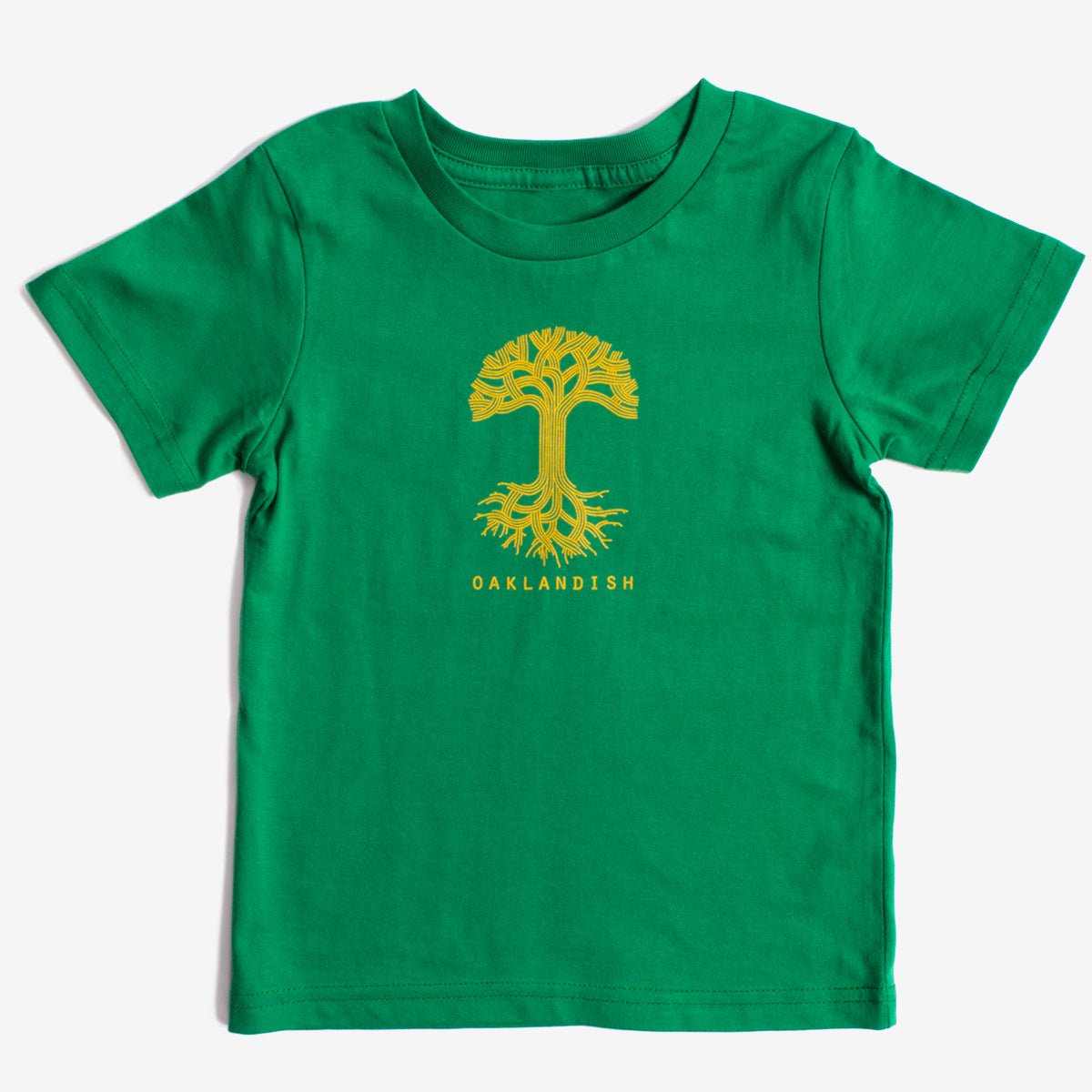 The Toddler Oaklandish Classic Logo Tee by Oaklandish is a Kelly green 100% cotton T-shirt featuring a large yellow tree with visible roots centered on the chest. Below the tree, "OAKLANDISH" is written in uppercase yellow letters. The T-shirt is displayed on a plain white background.