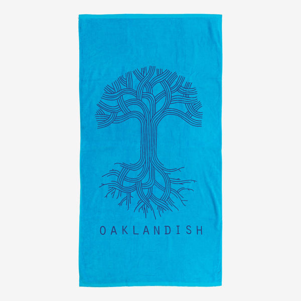 A plush oversized beach towel in aqua blue with a classic Oaklandish logo and wordmark.