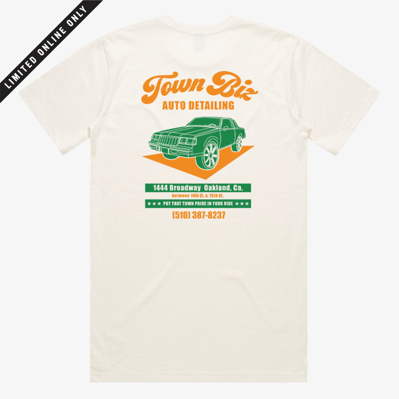 Back of creme t-shirt with orange and green Town Biz Auto Detailed ad with car and “Put that Town Pride in Your Ride” tagline.