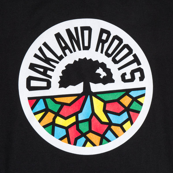 Close up of round full-color Roots SC logo on a black t-shirt.