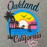 Detailed close-up of pink, black, yellow, and blue Oakland California Wonderland graphic on the chest of a heather grey t-shirt.