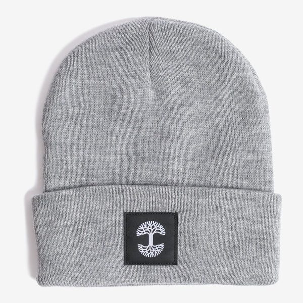 A grey woven cuffed beanie with a black and white Oaklandish logo tag on the cuff.