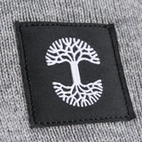 A close-up of the black and white Oaklandish logo tag on a grey woven beanie.
