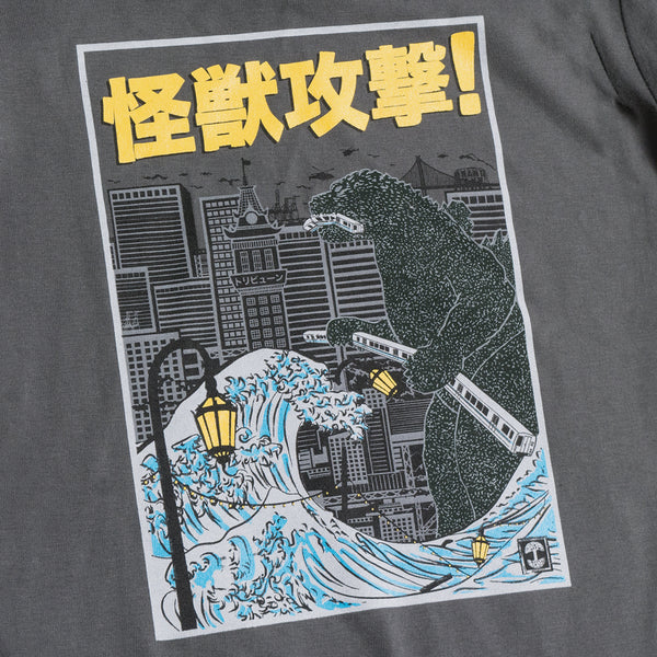 Close-up of graphic of Kaiju monster intent on destroying Oakland on a charcoal youth sized t-shirt.